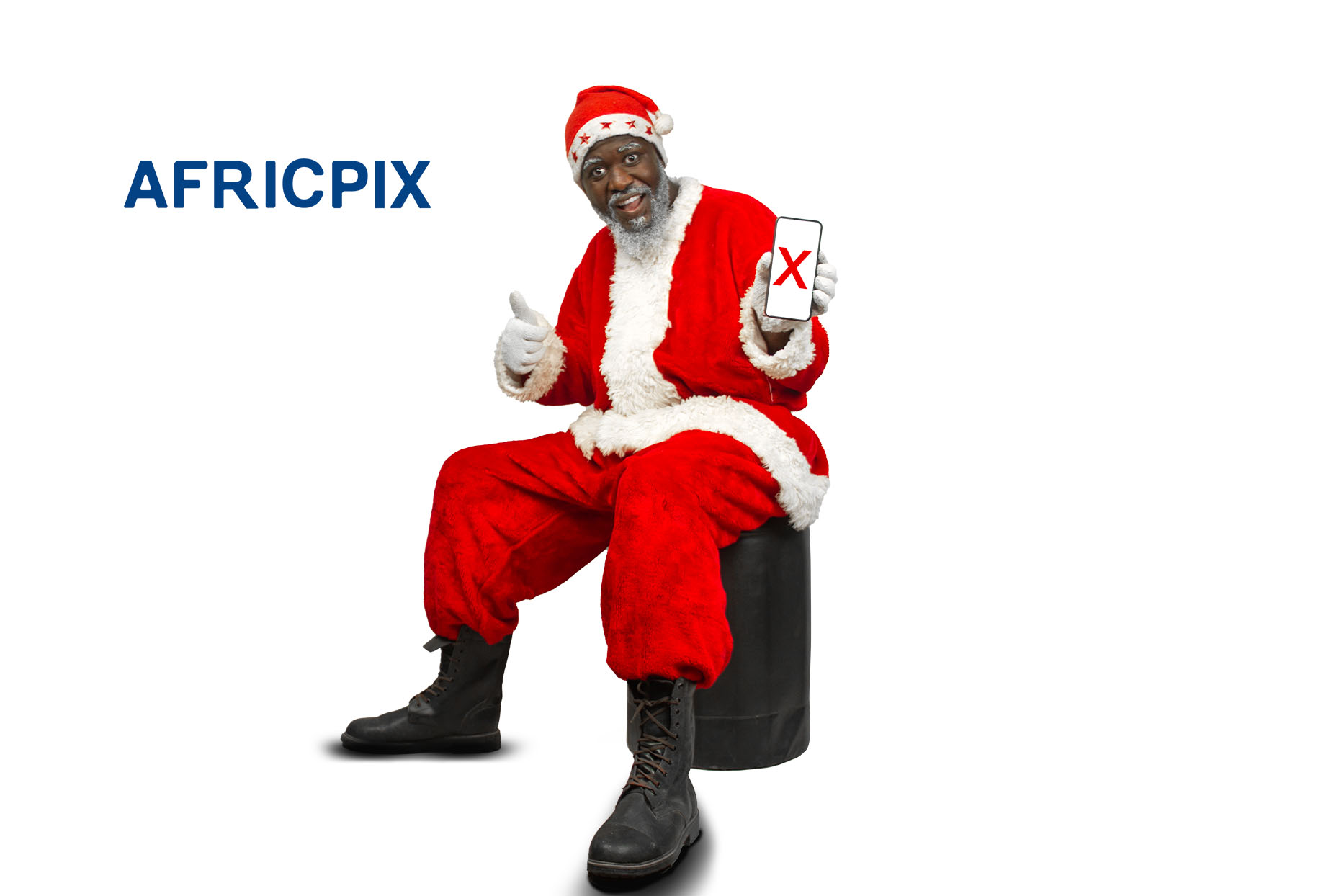 Santa Claus, also known as Father Christmas, sitting on a chair, giving a thumbs-up gesture while holding a smartphone.png